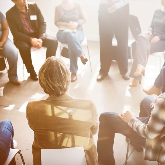 photo of diverse group of people seated in a circle